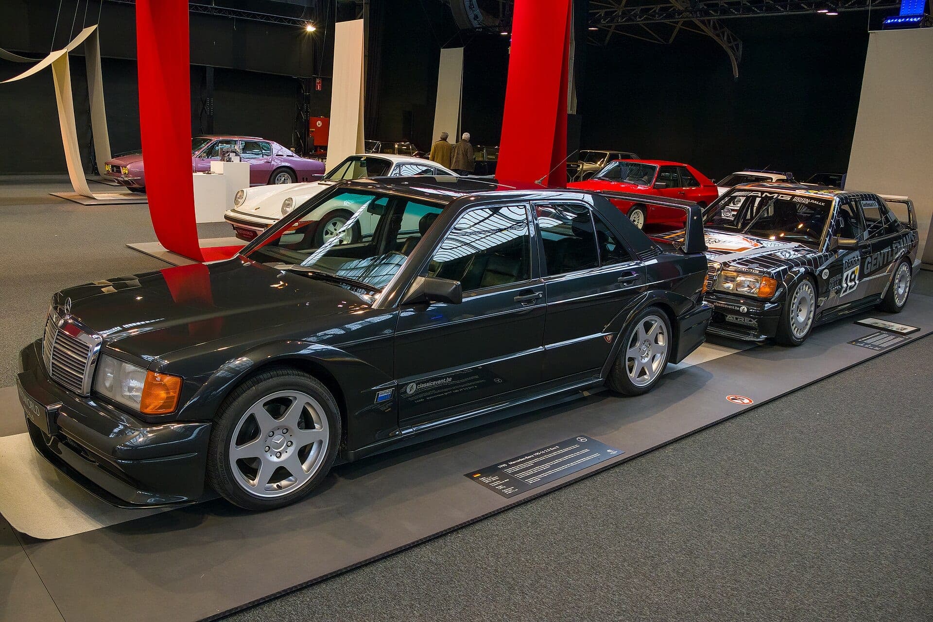 Mercedes-Benz 190E 2.5-16 Evolution II de calle en una exposición, con un ejemplar de carreras del mismo modelo detrás
